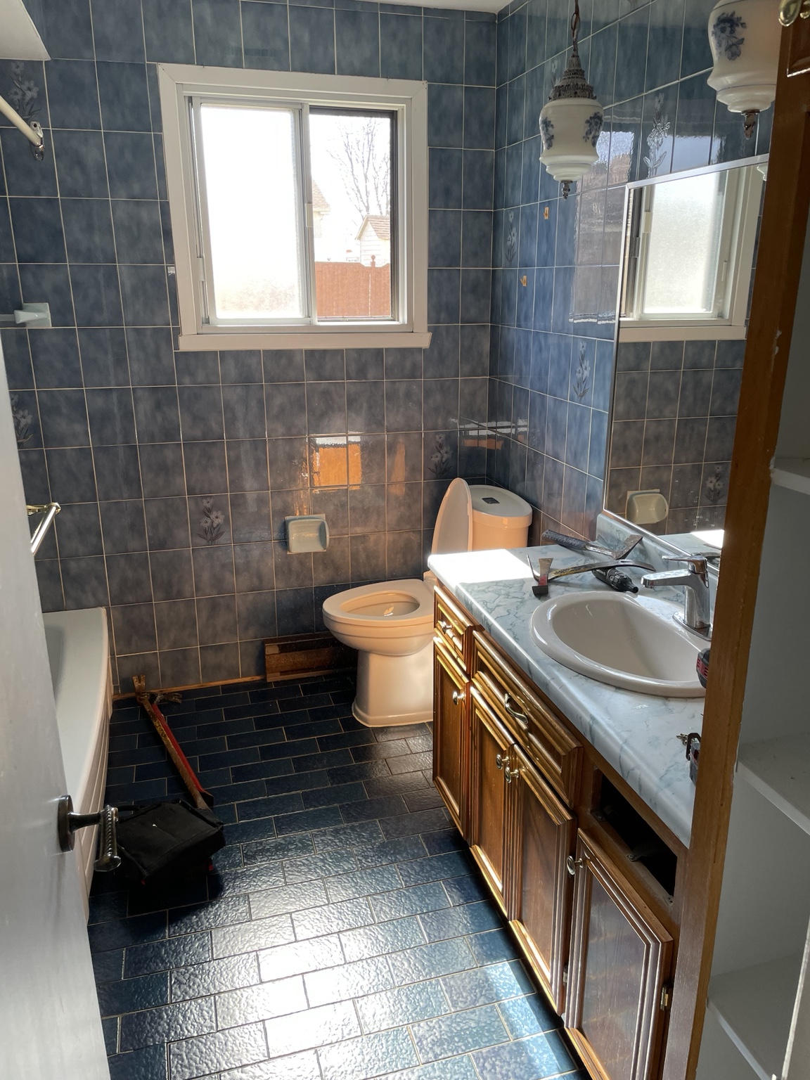 Bathroom before renovation with blue wall tiles